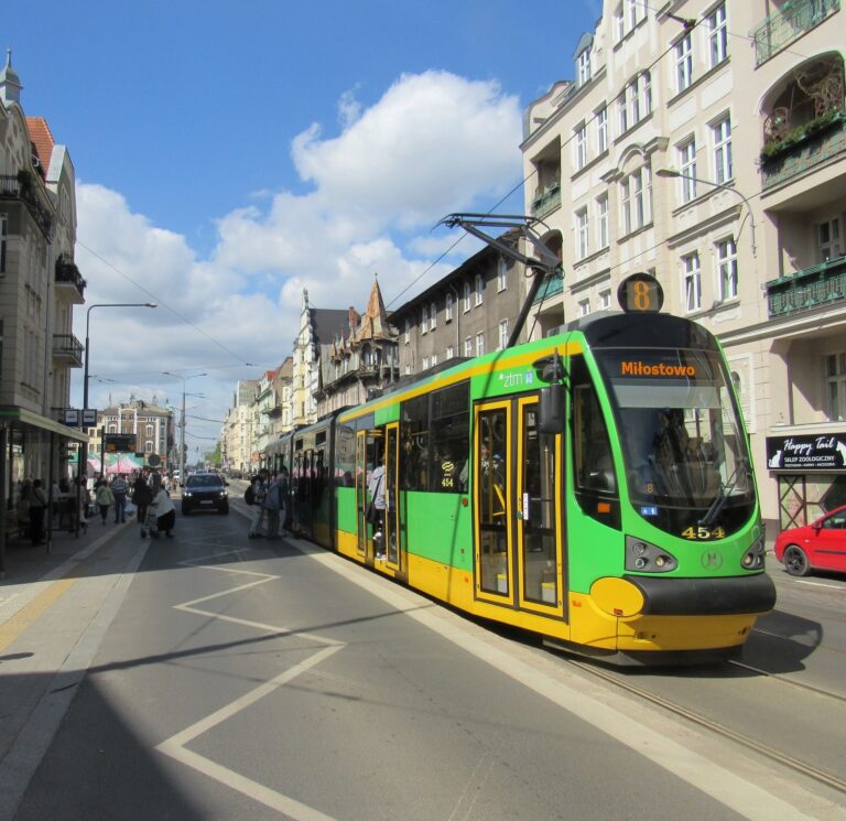 tramwaj linii numer 8 stoi na przystanku typu wiedeńskiego Rynek Jeżycki na ulicy Dąbrowskiego - pasażerowie wchodzą do pojazdu